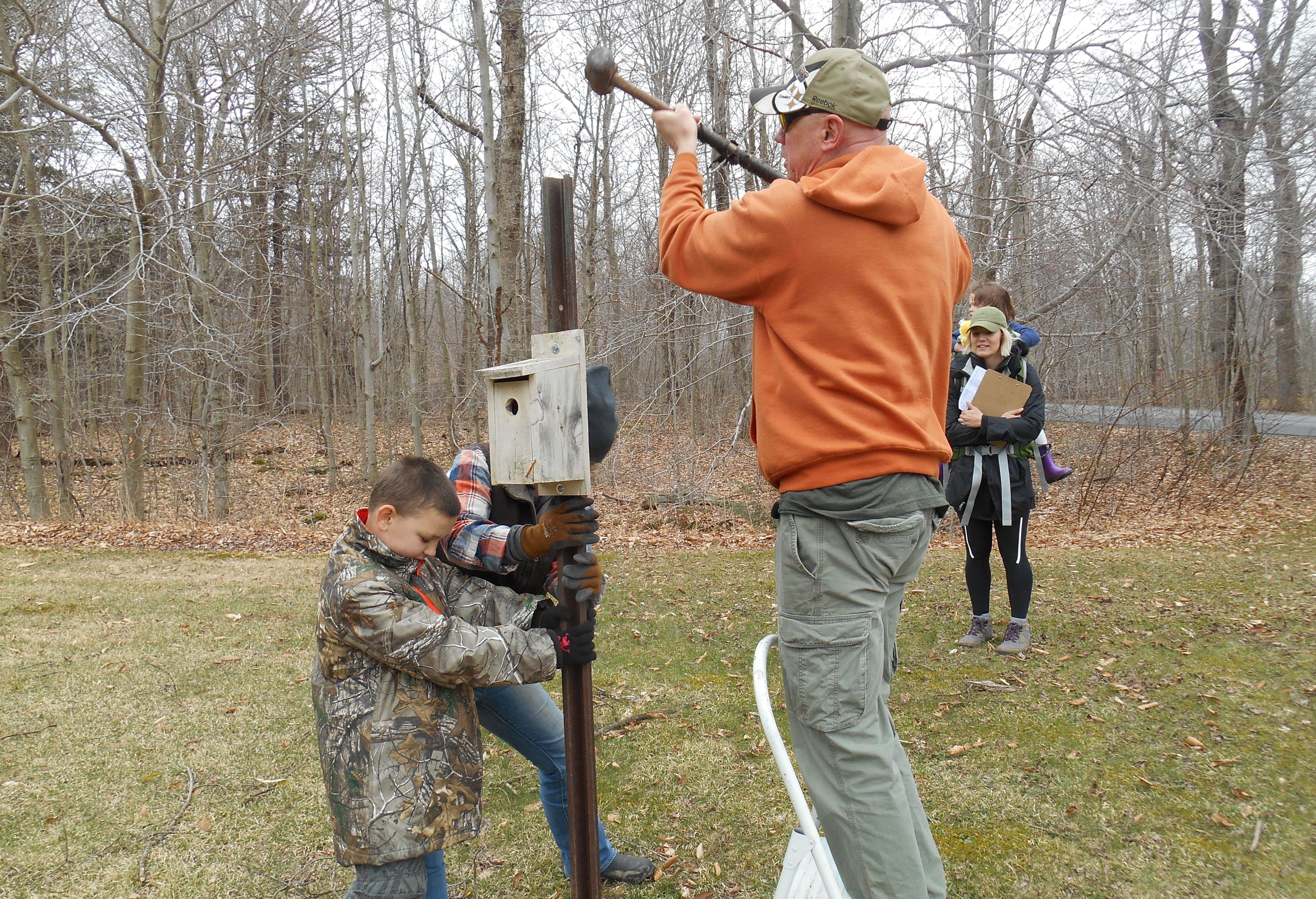 A family adjusting a nesting box. 