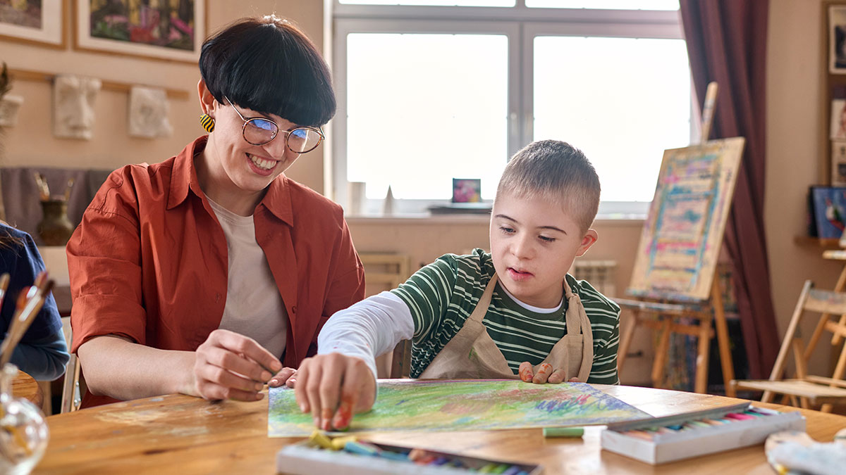 A support counselor is helping a child with an intellectual disability.