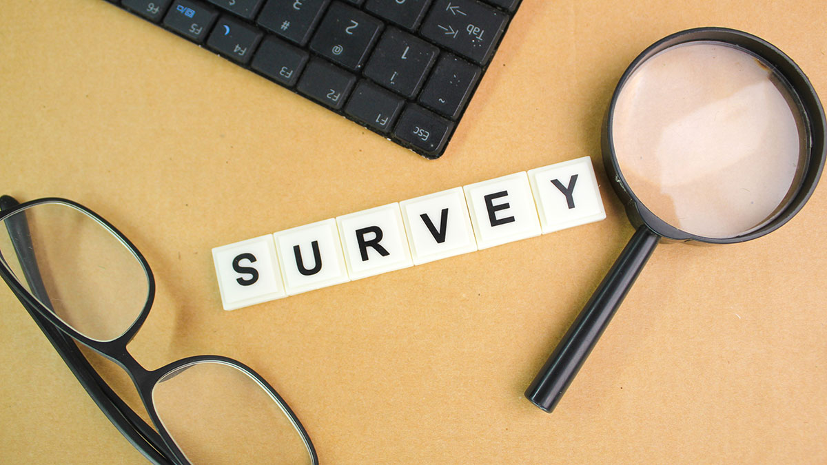 The word Survey, surrounded by a keyboard, eye glasses, and a magnifying glass.