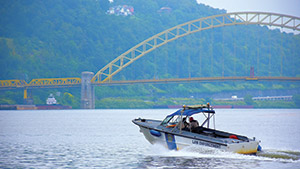 Motorboat cruising on river with bridge 