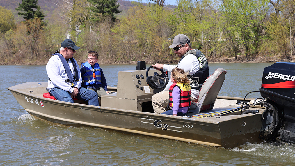 Family of four, all wearing life jackets, enjoying a boat ride on the Susquehanna River