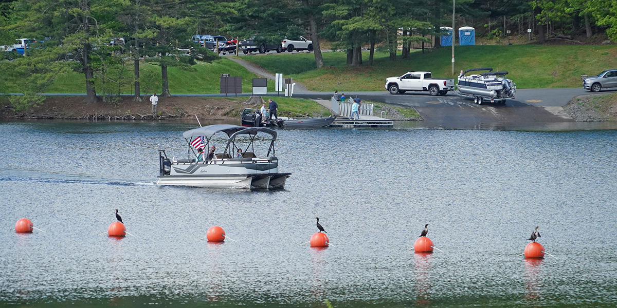 A pontoon boat driving near net buoys on Lake Wallenpaupack in Northeast Pa