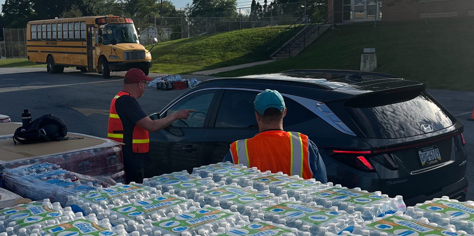 Volunteers and emergency officials distribute bottled water during a water main break.