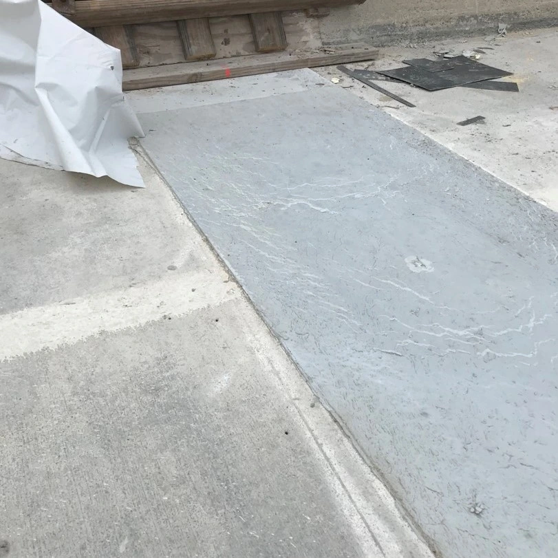 A close-up image of a concrete link slab covering a bridge deck joint during the finishing process.