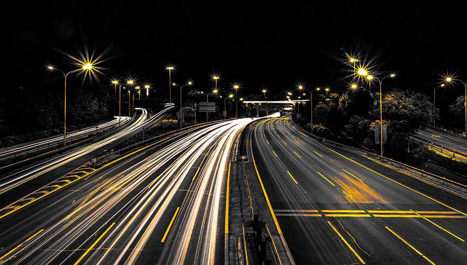 A highway at night with traffic headlights streaked by long exposure