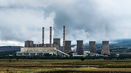 A power plant with smokestacks and cooling towers