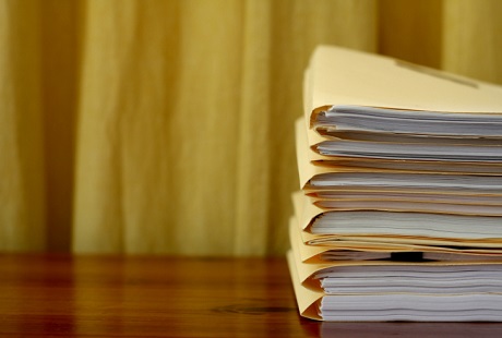 Folders holding report papers on a wooden desk