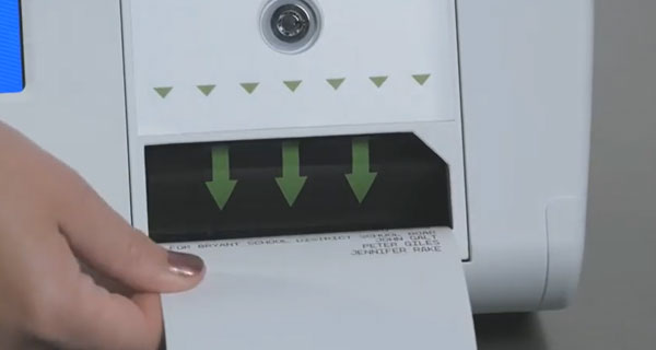 Person placing their ballot into the ballot scanner