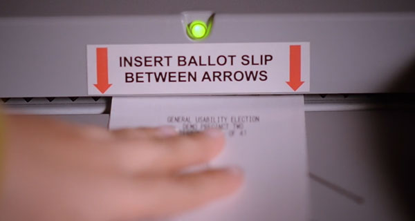 Person placing their ballot into the ballot scanner