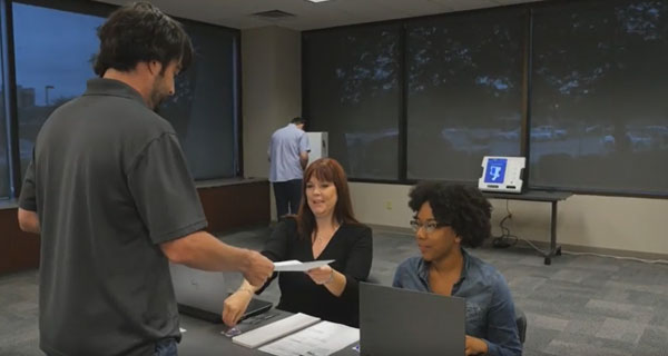 Poll workers greeting a voter
