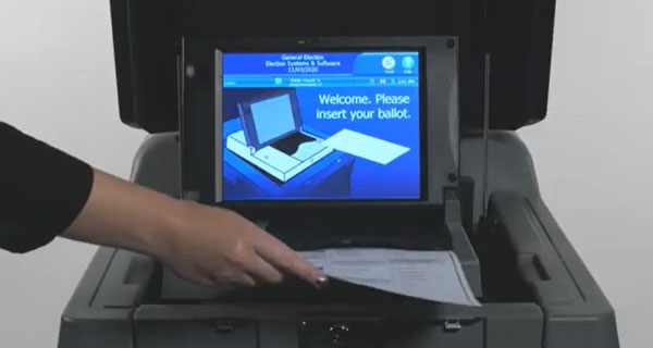 Person placing their ballot into the ballot scanner