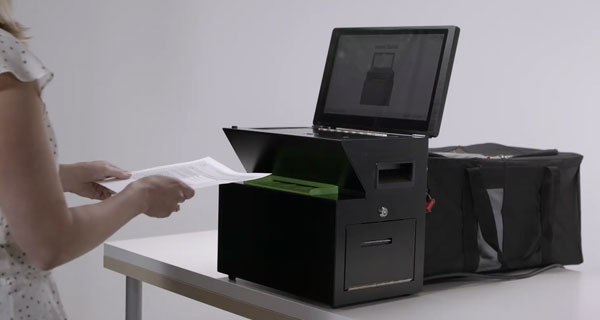 Person placing their ballot into the ballot scanner
