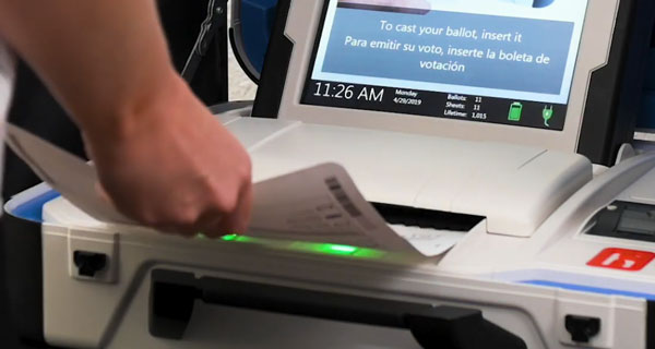 Person placing their ballot into the ballot scanner
